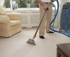Carpet cleaning professional removing dirt and stains with a hot-water extraction tool in a home, Syracuse, NY.
