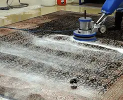 Professional rug cleaning with a rotary floor machine and shampoo foam, deep-cleaning an area rug, in Syracuse, NY.
